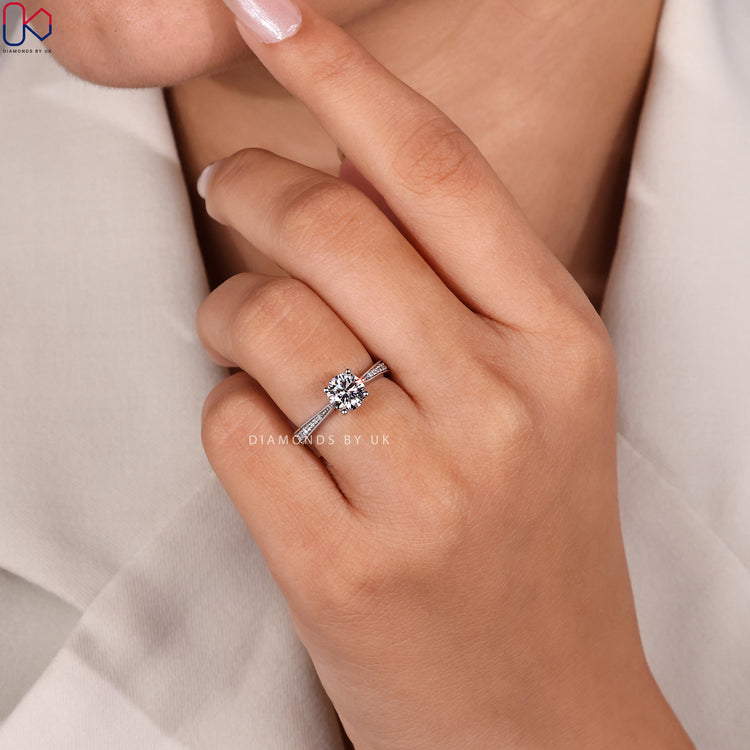Four prong round cut diamond ring with pavé shank
