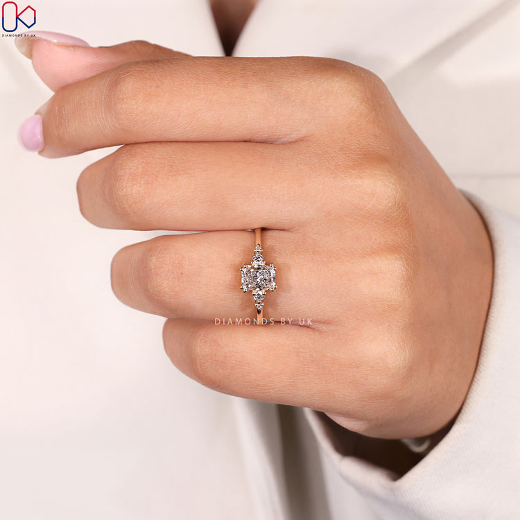 Round side stone radiant cut ring with prongs.