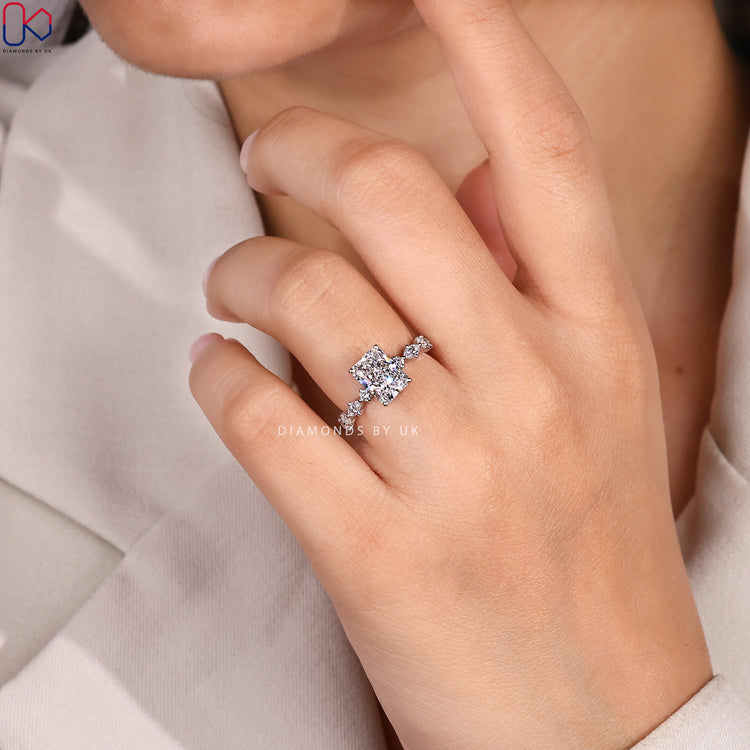 Radiant diamond ring with marquise and round pavé.