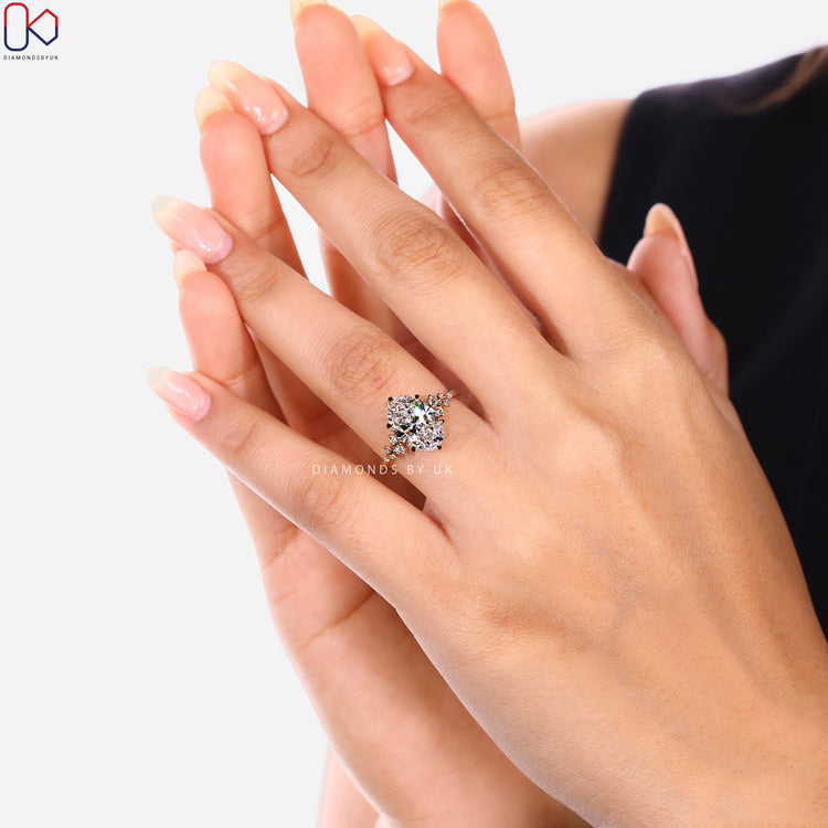 Handmade oval diamond ring with round side stone style.  
