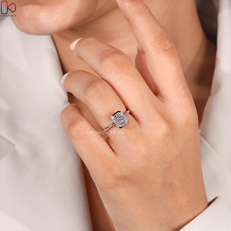 Radiant diamond ring with bezel and cathedral style.