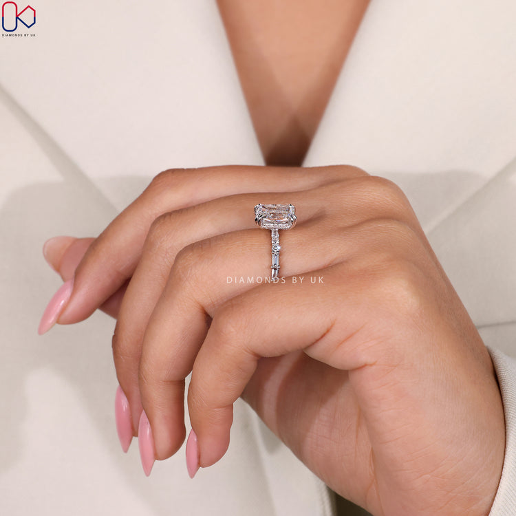 Radiant cut engagement ring with a pave band and hidden halo.
