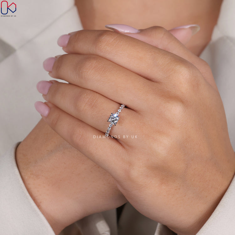 Buy engagement ring featuring a cushion cut diamond in a secure claw prong eternity setting.