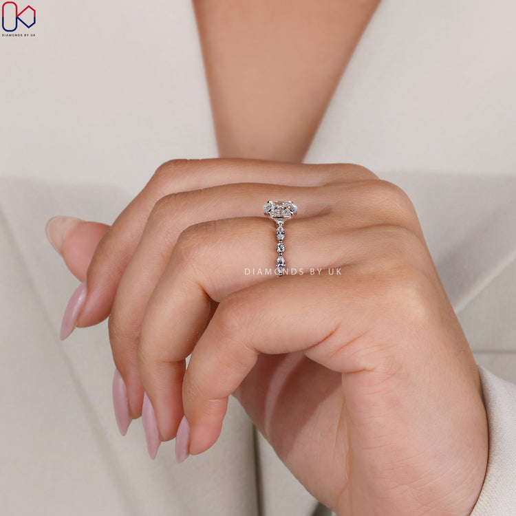 White gold engagement ring with a 4 prong claw setting holding an oval lab diamond.
