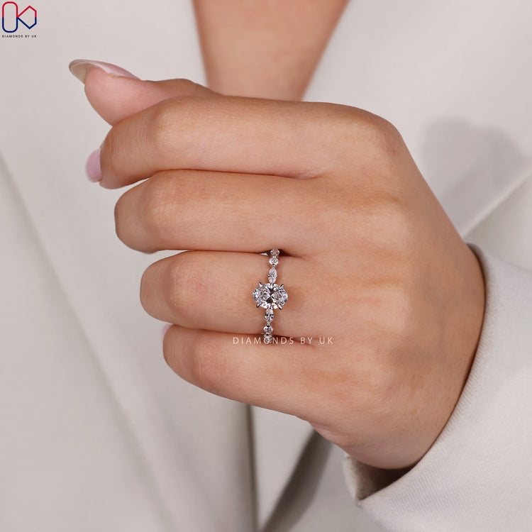 Buy engagement ring with marquise and round diamonds flanking an oval centrepiece.