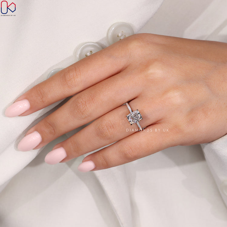 4 claw prong setting secures the cushion diamond in this white gold engagement ring.