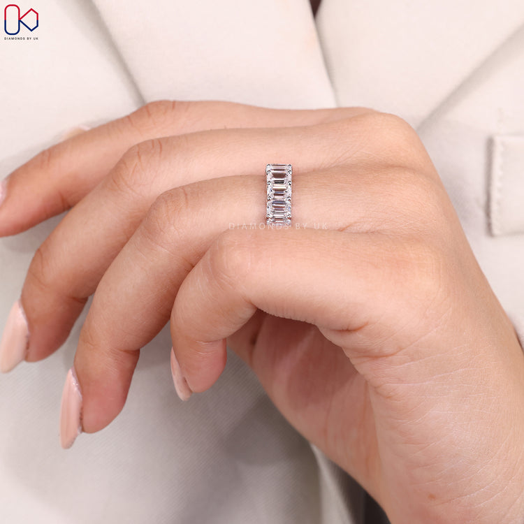 Shared prong wedding band with emerald cut stones.
