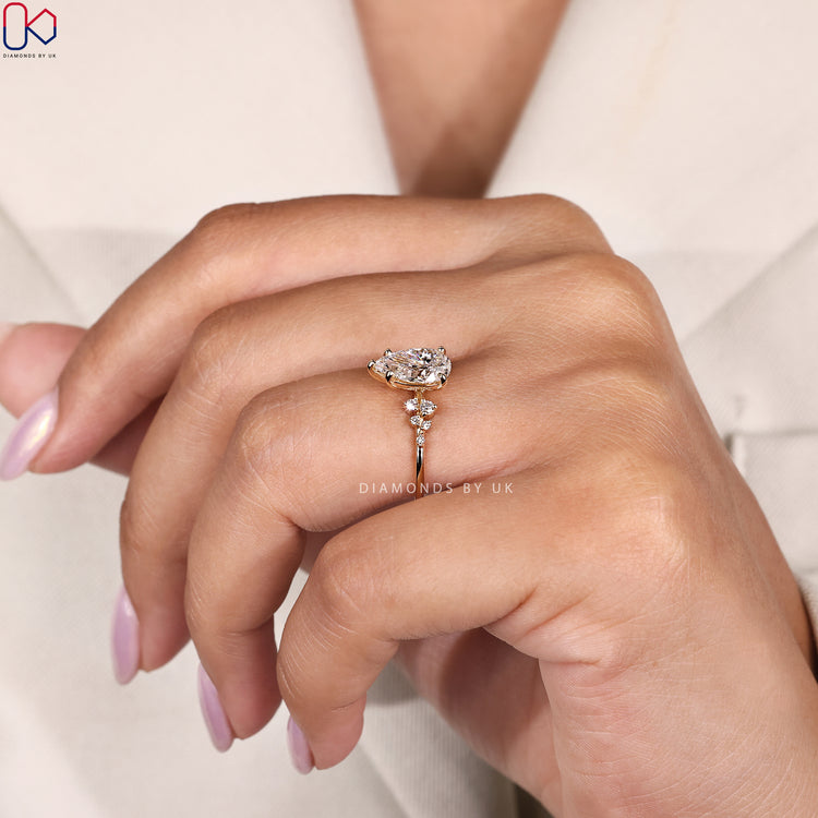 Yellow gold diamond band with pear shaped centre stone.

