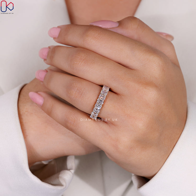Custom wedding band in yellow gold with a radiant cut half eternity style.
