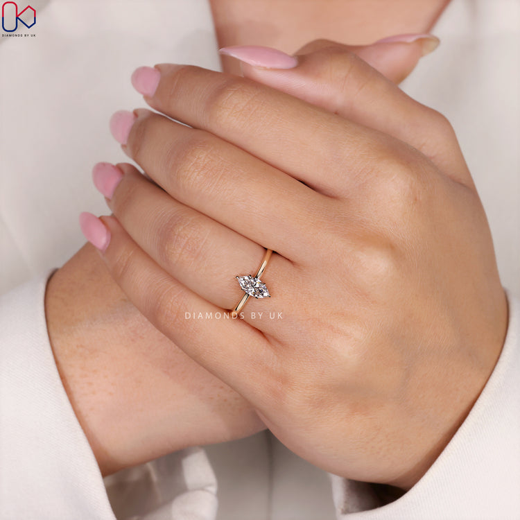 Diamondsbyuk gold marquise engagement ring with a six-prong setting.
