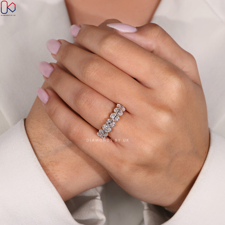 Yellow gold diamond band featuring handmade oval cut design.
