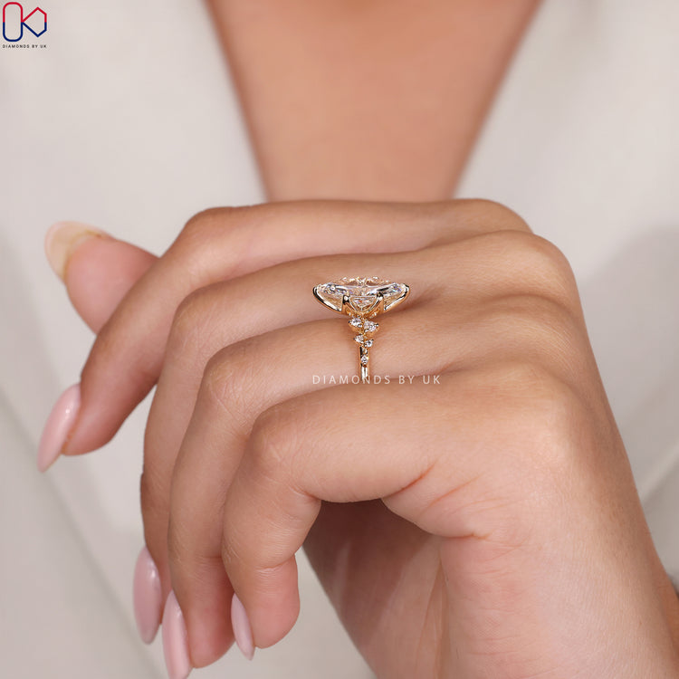 Side stone engagement ring with marquise cut diamond.
