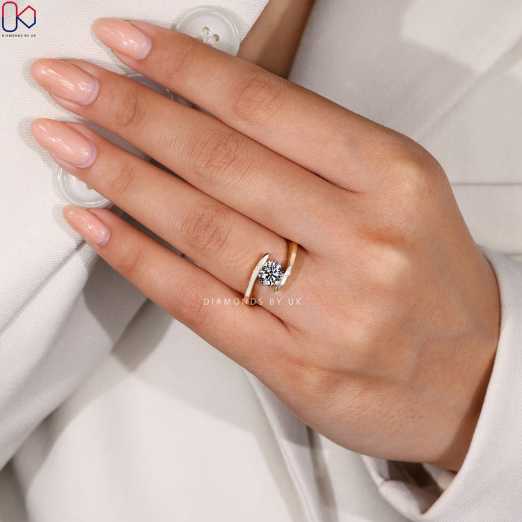 Handmade ring with smooth bypass curves and a round diamond focal point.