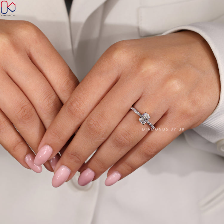 White Gold Engagement Ring with a hidden halo and cushion diamond center, complemented by round side stones.
