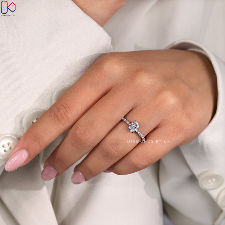 Diamondsbyuk Ring with a cushion brilliant cut diamond, round side diamonds, and hidden halo for an elegant engagement.