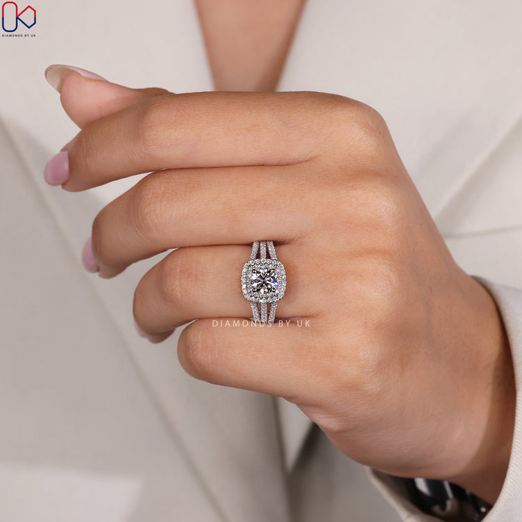 White gold ring featuring a round diamond framed by two halos and pave accents.