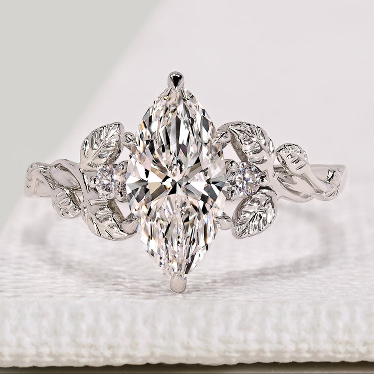 Marquise cut diamond ring with round diamond side stones.
