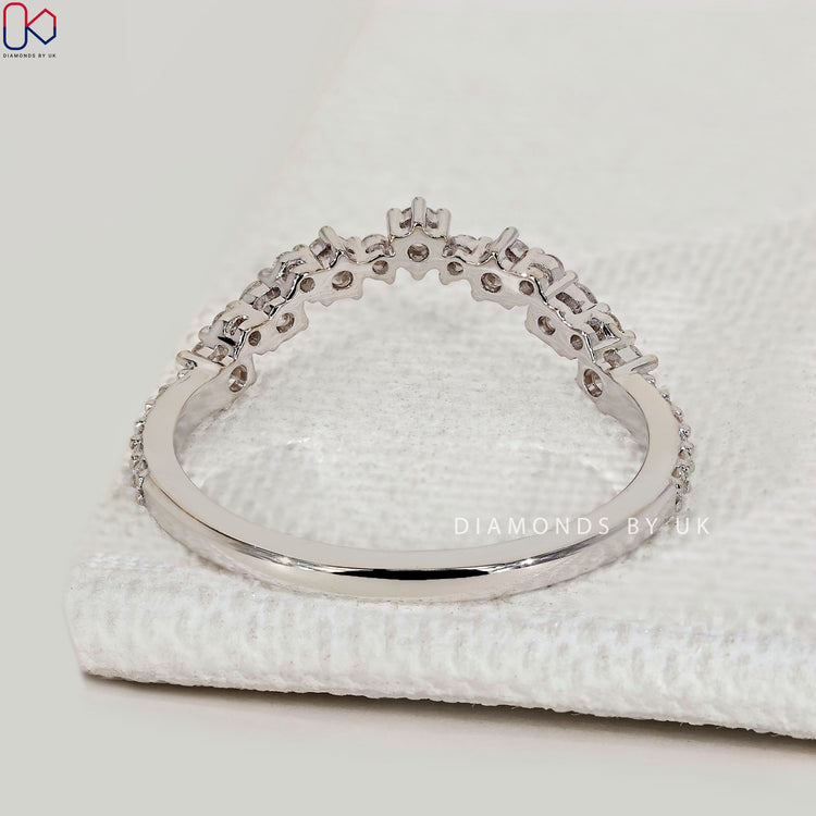 Round cut diamond wedding band with curved style.