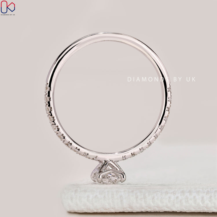 Oval cut ring with pavé band and four claws.