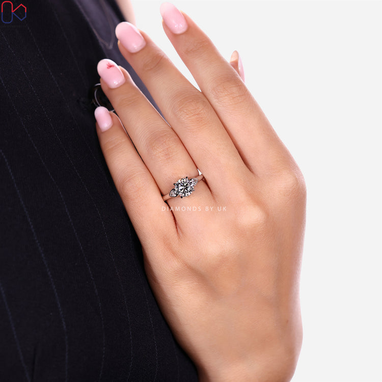 Lab grown three stone diamond ring with pear side stones.
