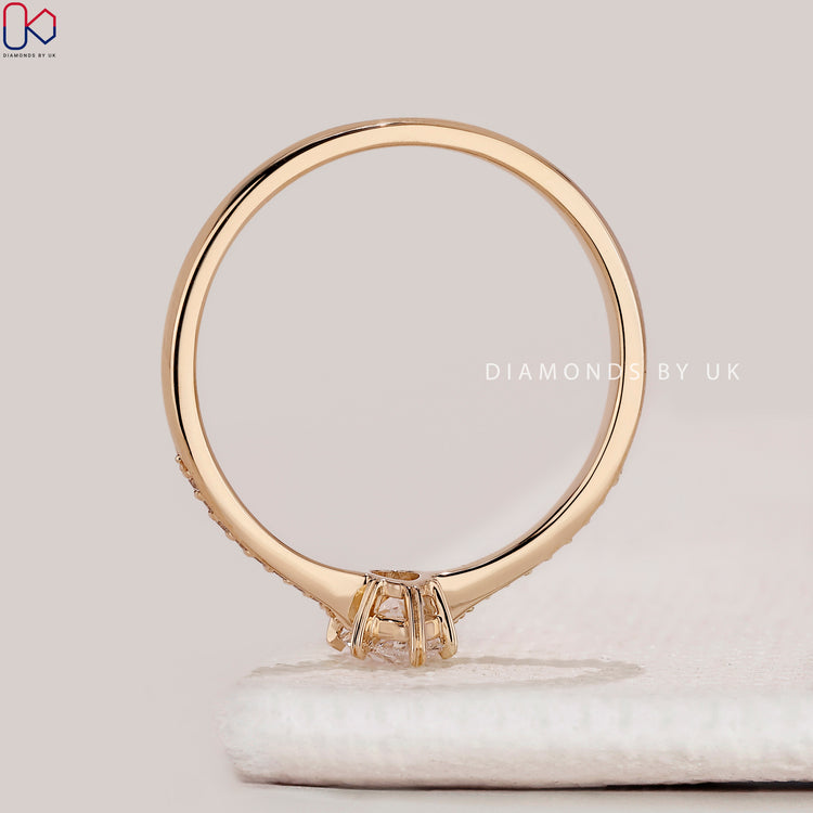 Pear cut ring with round diamonds and heart prongs.