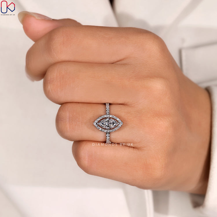 Marquise ring with round diamond halo and pavé.
