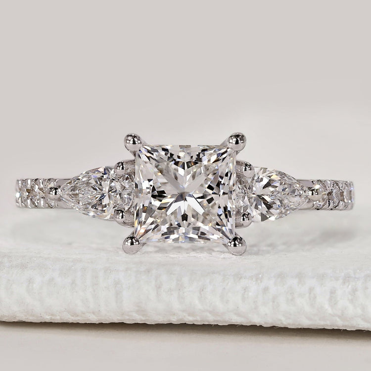 Princess cut ring with pear side stones and pavé.