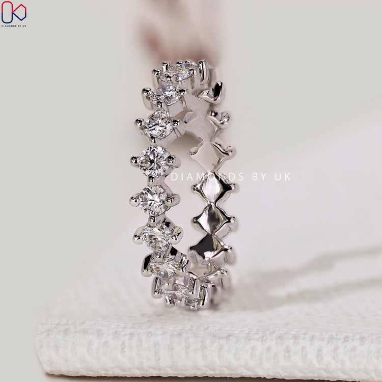 Handmade eternity diamond band with compass prongs.