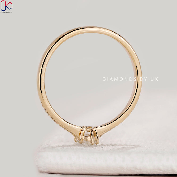 Pear cut ring with round diamonds and heart prongs.