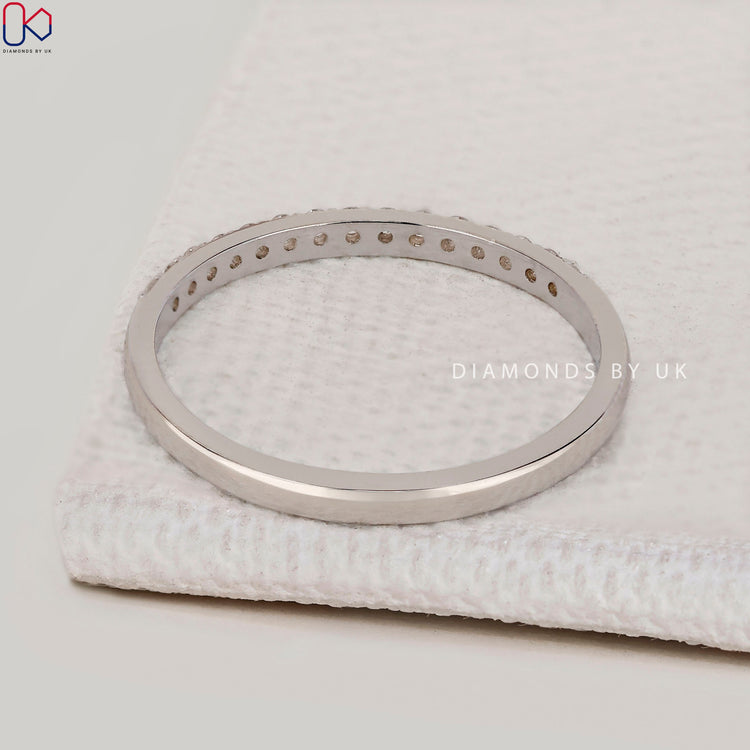 Lab grown round diamond wedding band with prongs.