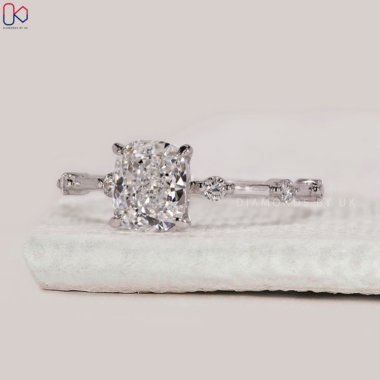 Round cut pave band ring with cushion centre stone.
