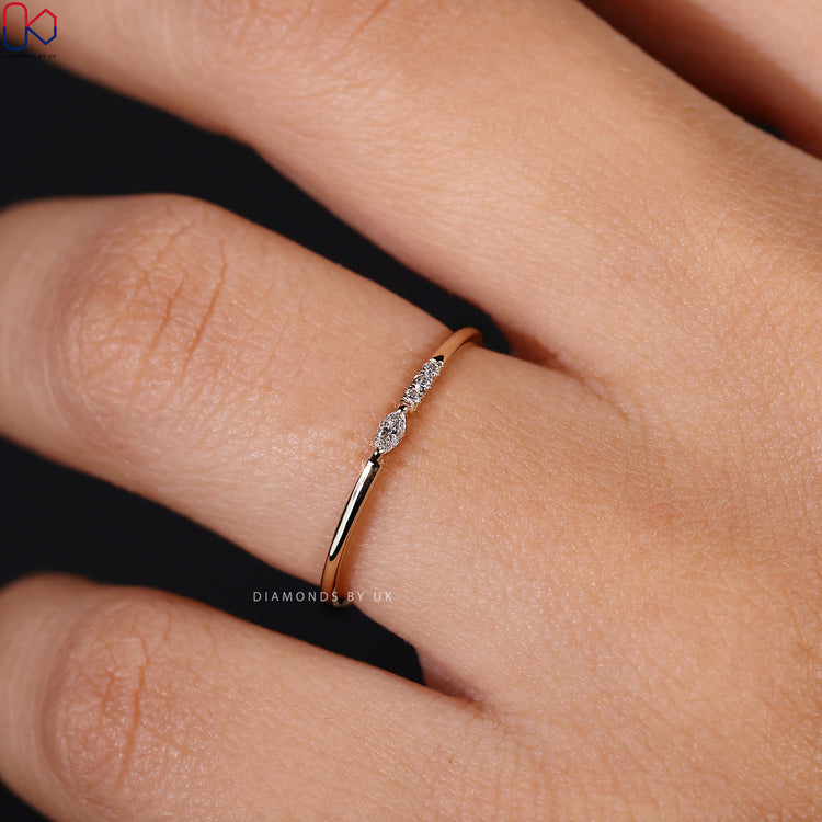Prong set diamond band holding four lab grown stones in a dainty finish.
