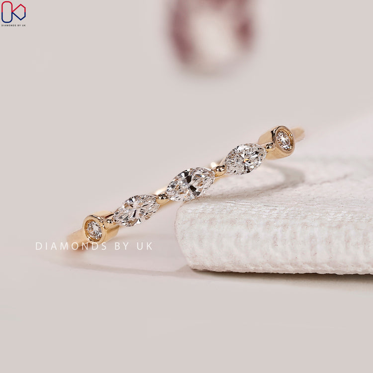 Marquise and round diamond band in half eternity style.
