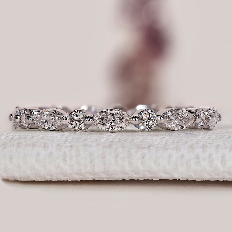 Marquise and round diamond wedding band with shared prongs.
