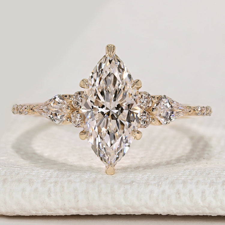 Marquise cut diamond ring with kite and round side stones.
