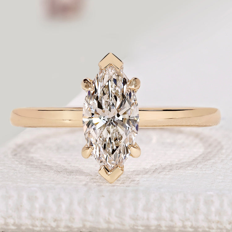 Marquise cut solitaire ring with V and claw prongs.