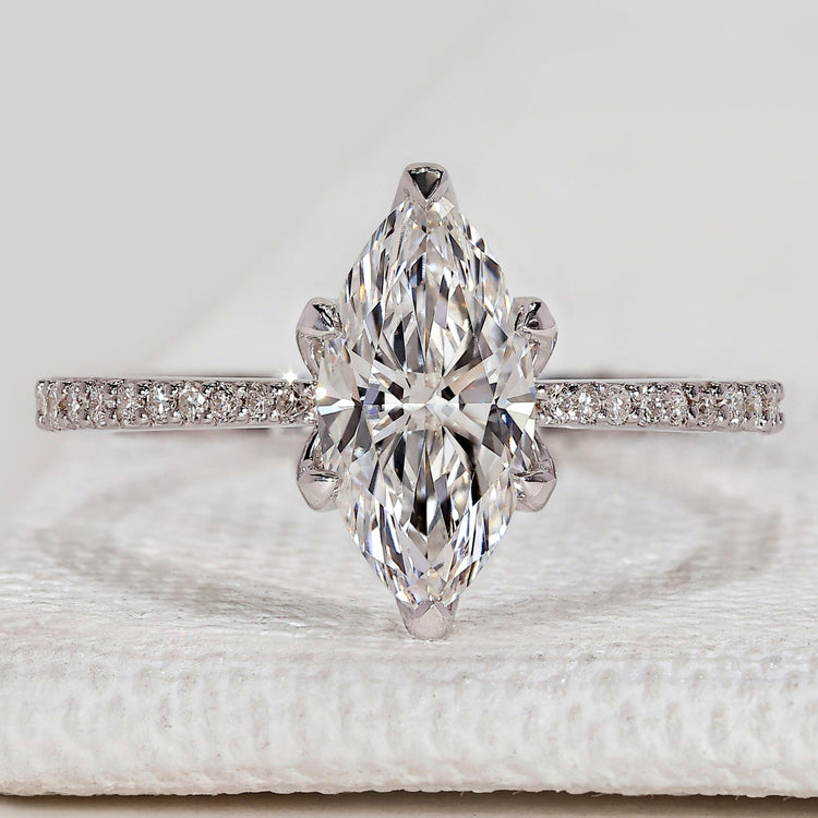 Marquise engagement ring with round diamond pavé.
