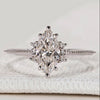 Marquise ring with round side stones and milgrain.
