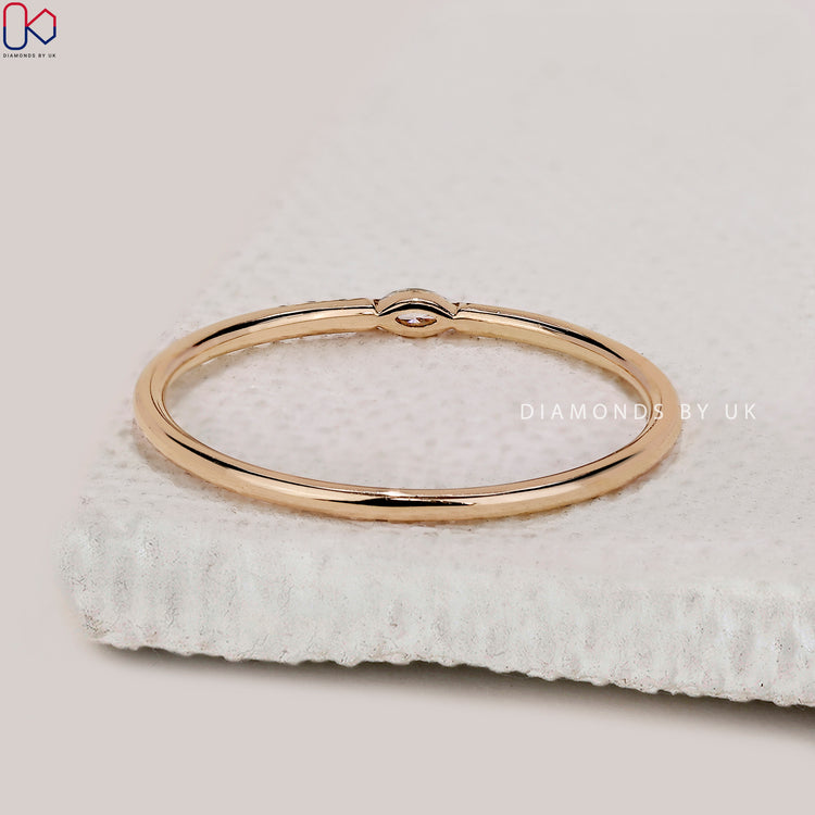 Round diamond wedding band featuring tiny stones in a minimalist layout.

