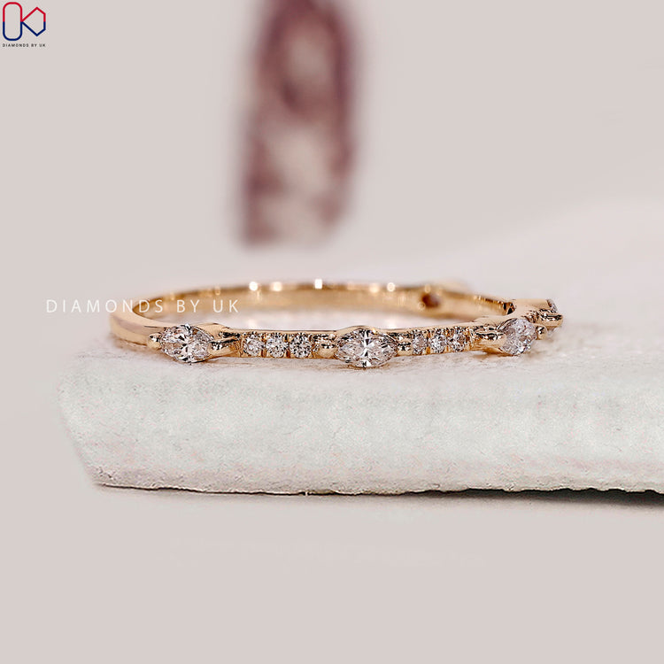 Marquise and round diamond wedding band styled in a delicate half eternity layout.
