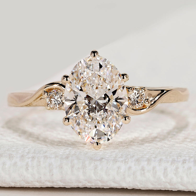 Oval cut engagement ring with round side stones.