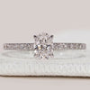 Oval cut diamond ring with round diamond pavé.