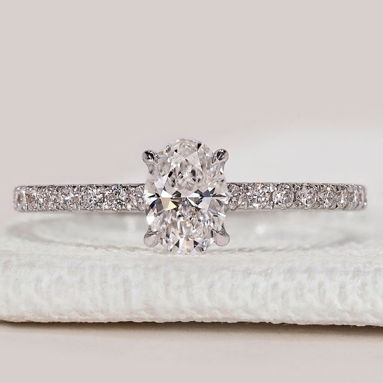 Oval cut diamond ring with round diamond pavé.