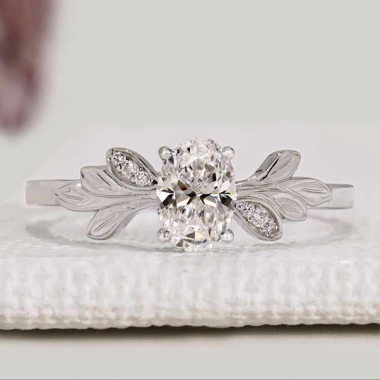 Oval cut engagement ring with round diamond side stones.