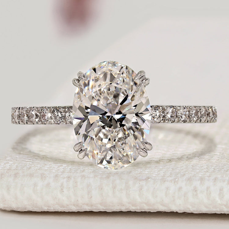 Oval cut engagement ring with hidden halo and pavé style.
