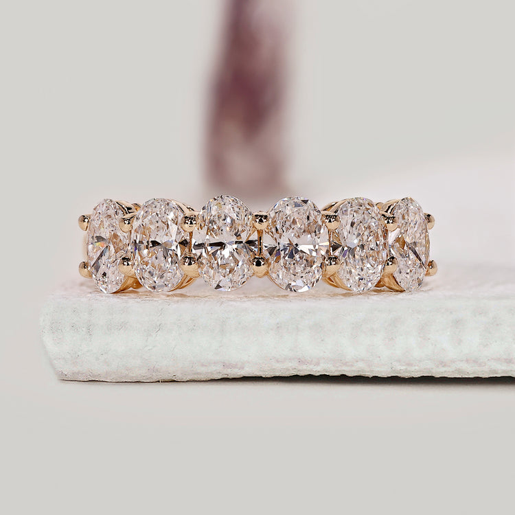Oval diamond wedding band crafted in yellow gold for a refined half eternity look.
