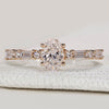 Oval diamond ring with shared prong pavé setting.