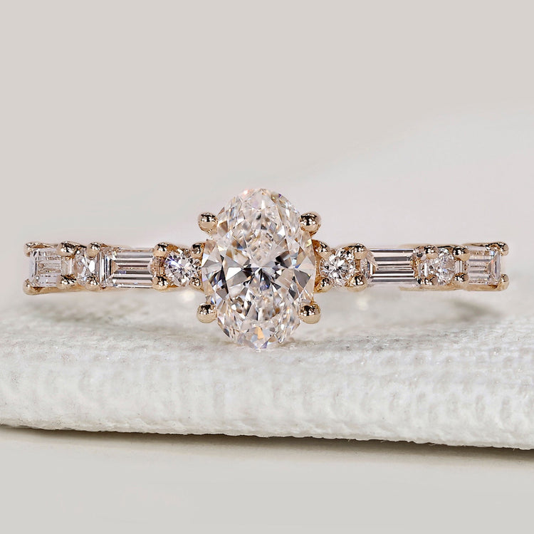 Oval diamond ring with shared prong pavé setting.