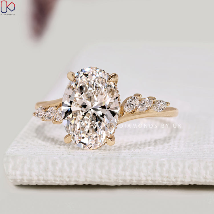Oval diamond ring with hidden halo and round diamonds.