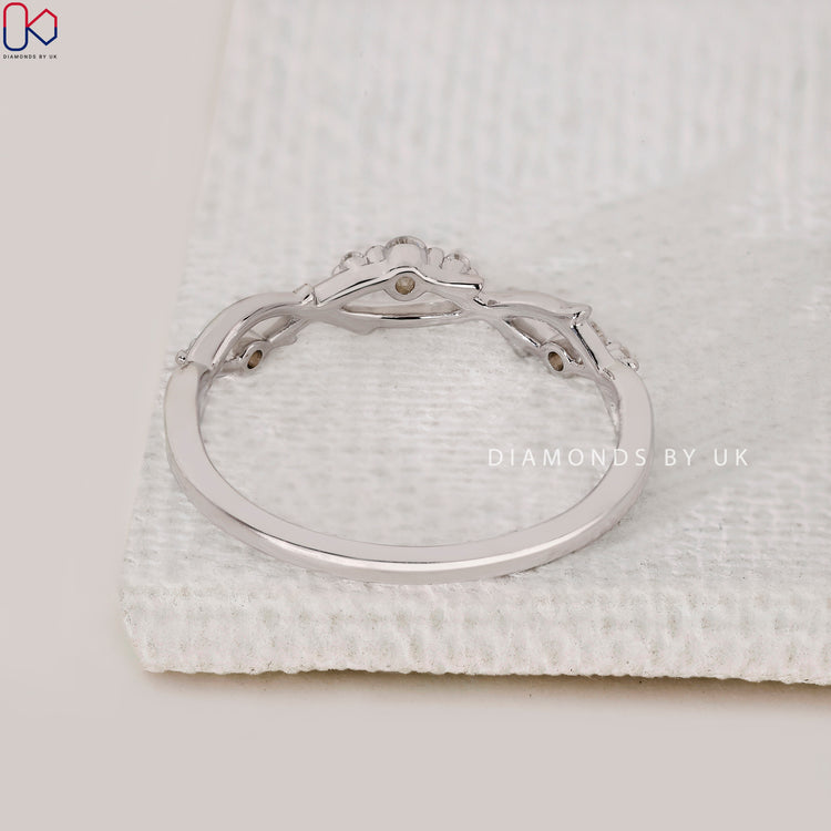 Prong set wedding band with a twisted and leaf-inspired gold design.
